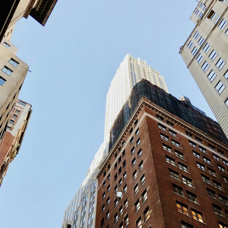 A view of tall downtown buildings from the ground.