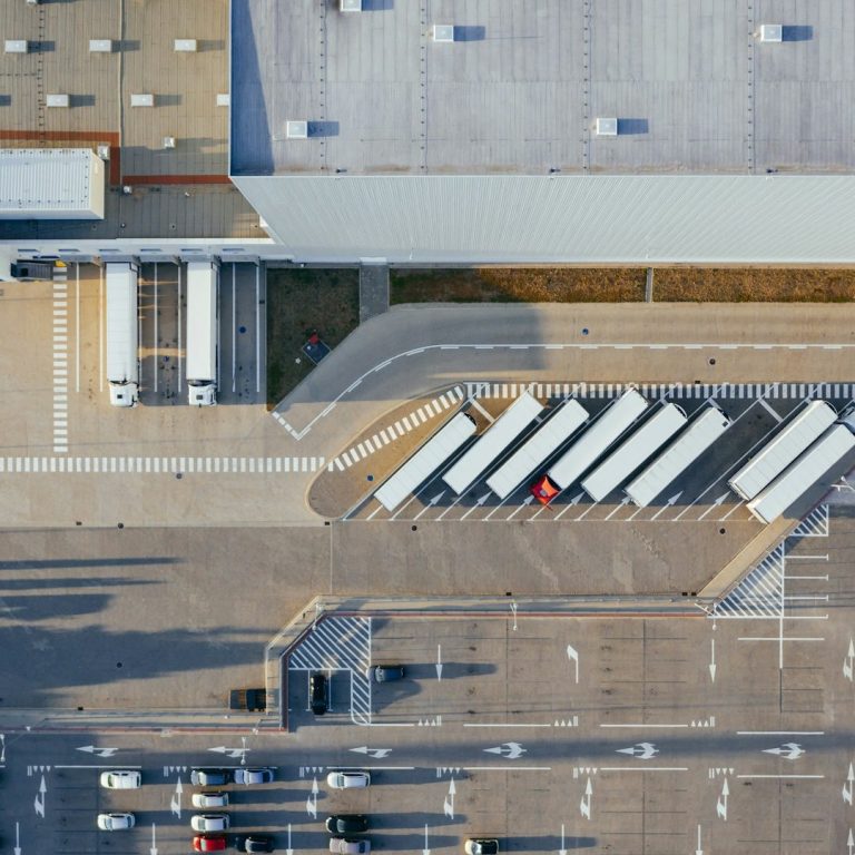 An aerial view of a warehouse with docking bays for large trucks.
