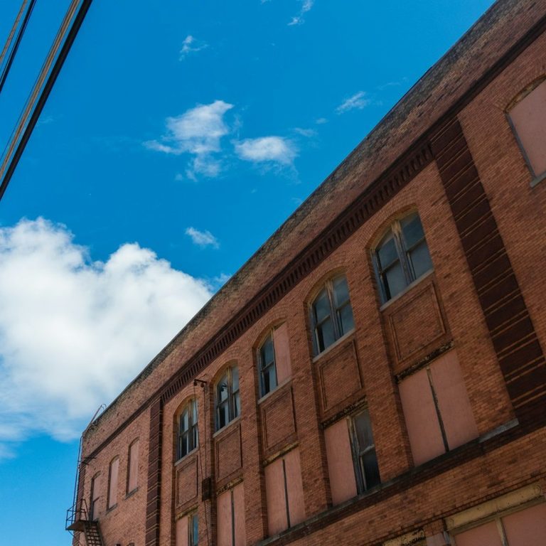 A large brick office building against a clear blue sky.